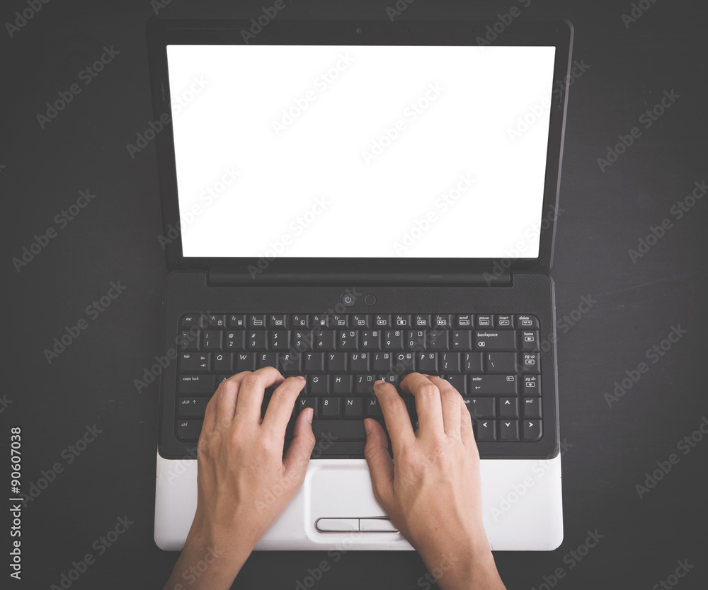 Hands typing on black laptop keyboard on black background, mock Hands typing on black laptop keyboard on black background, mock