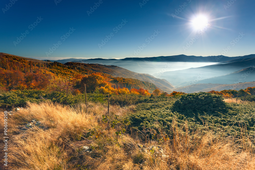 Fototapeta premium Autumn mountain scenery against rising sun