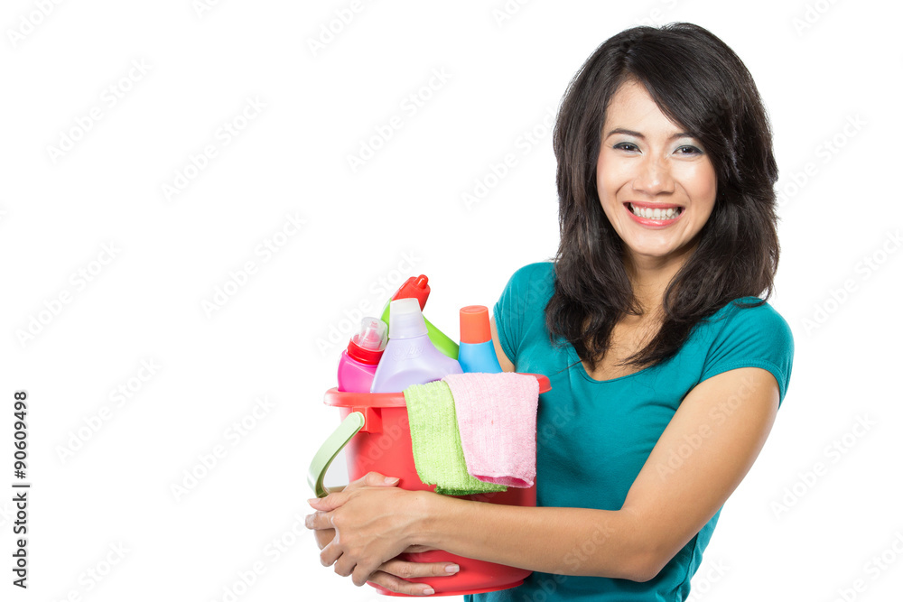 woman holding a basket full of cleaning products ready to do som woman holding a basket full of cleaning products ready to do som