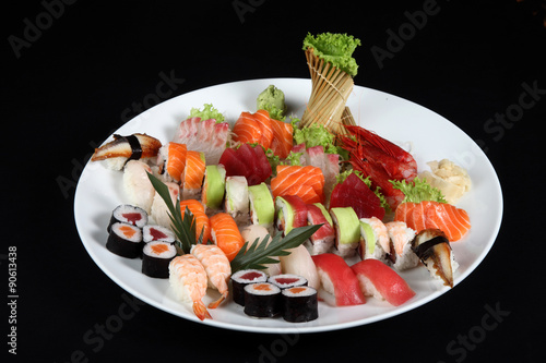 sushi and sashimi mixed on round white plate
