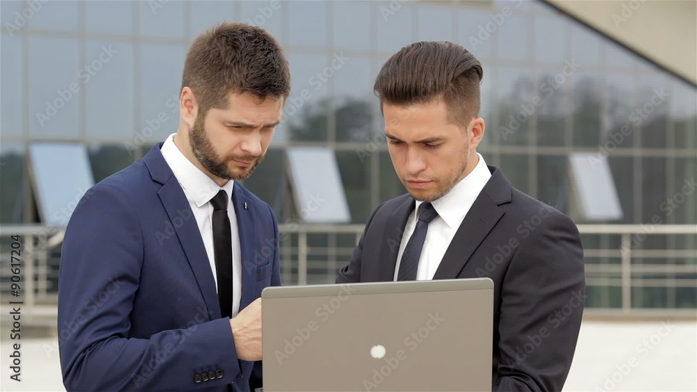 Business partners using a laptop during a meeting Business partners using a laptop during a meeting
