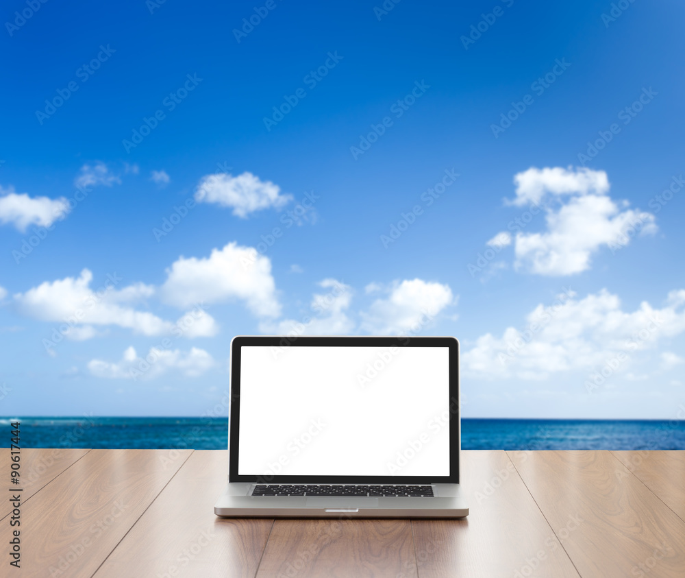 Laptop computer on wood table with sea background Laptop computer on wood table with sea background