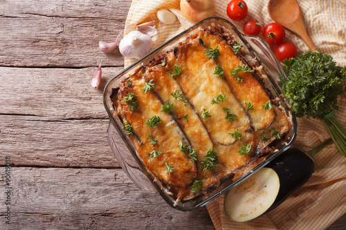 Greek moussaka in baking dish with the ingredients. horizontal top view
