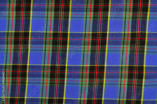 Scottish tartan pattern. Blue with red and yellow plaid print as background.