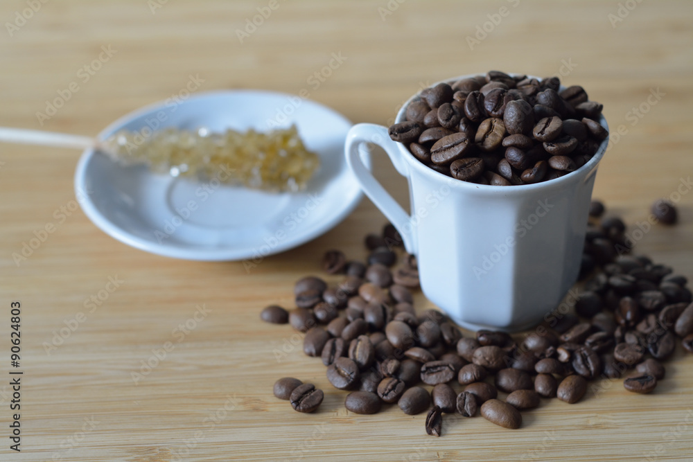 cup of coffee beans and a sugar stick cup of coffee beans and a sugar stick