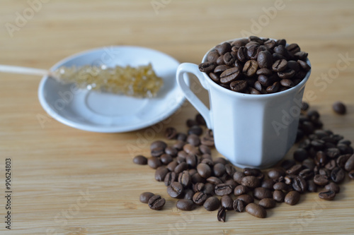 cup of coffee beans and a sugar stick