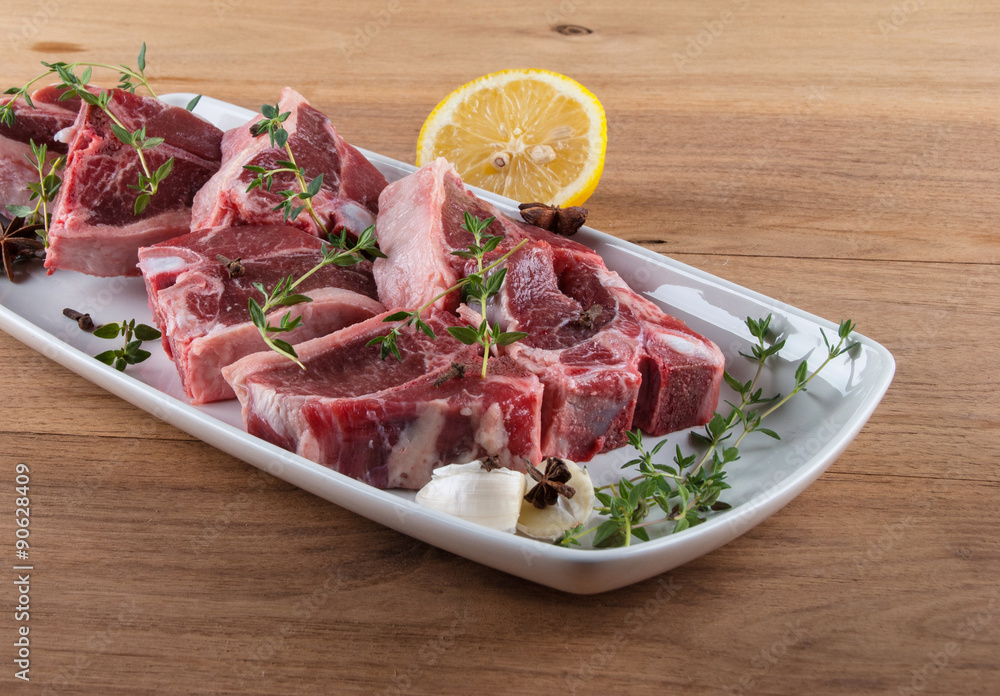 Raw lamb chops with spices and herbs on wooden background