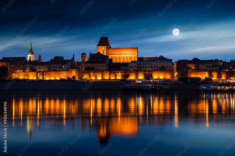 Obraz na płótnie Old town reflected in river at sunset. Torun, Poland. w salonie