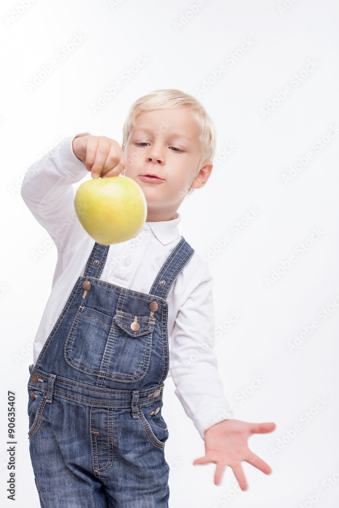 Cheerful small boy is eating healthy fruit Cheerful small boy is eating healthy fruit