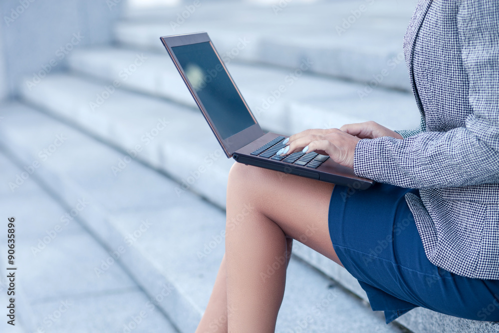 Naklejka premium Professional young female worker is using a laptop