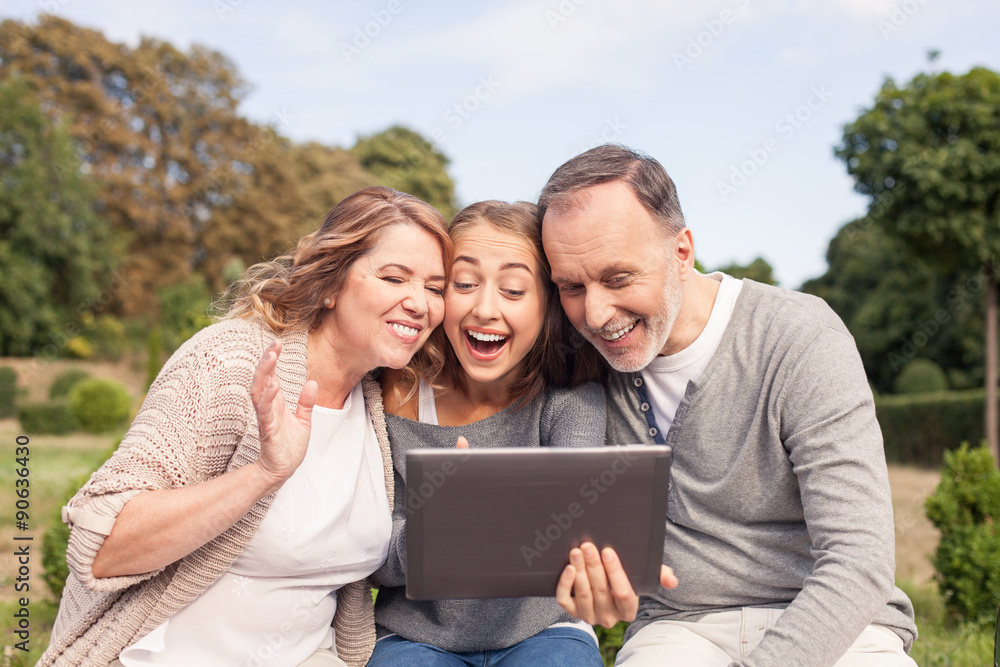 Beautiful girl is showing tablet to her old parents Beautiful girl is showing tablet to her old parents