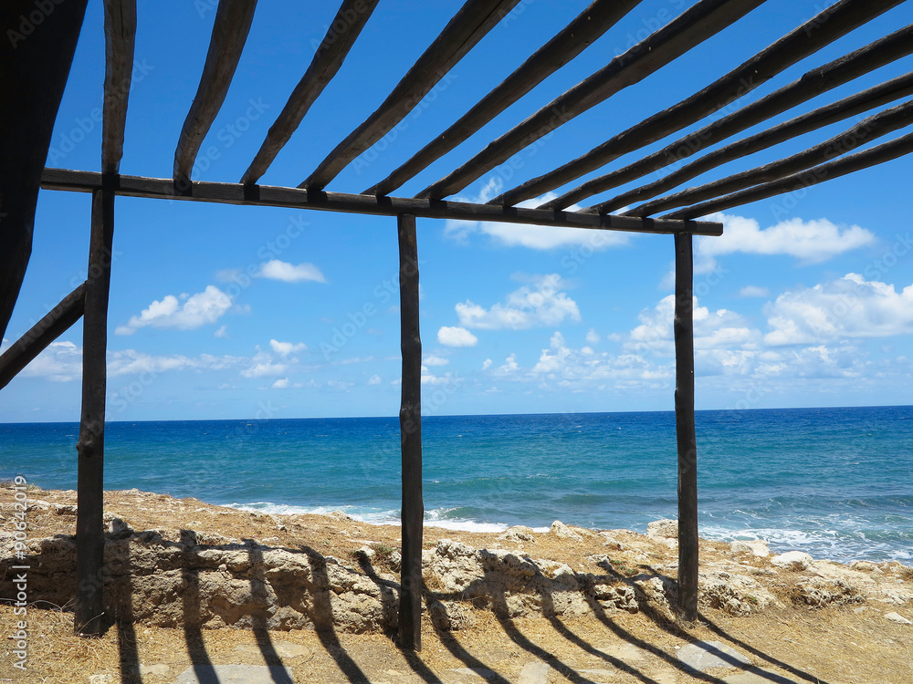 Old wooden canopy on the sea coast and blue sky