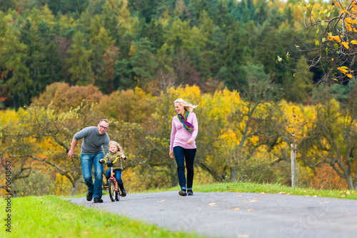 Vater zeigt Tochter Fahrradfahren bei Familien Spaziergang im Herbst Park 