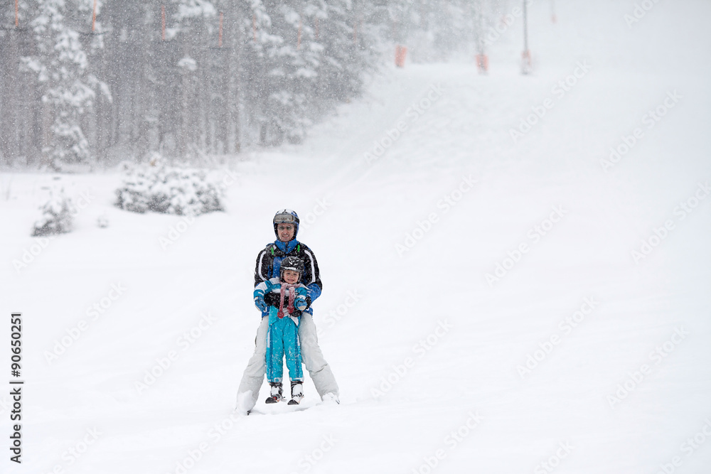 Father and son, skiing in the winter, boy learning to ski Father and son, skiing in the winter, boy learning to ski