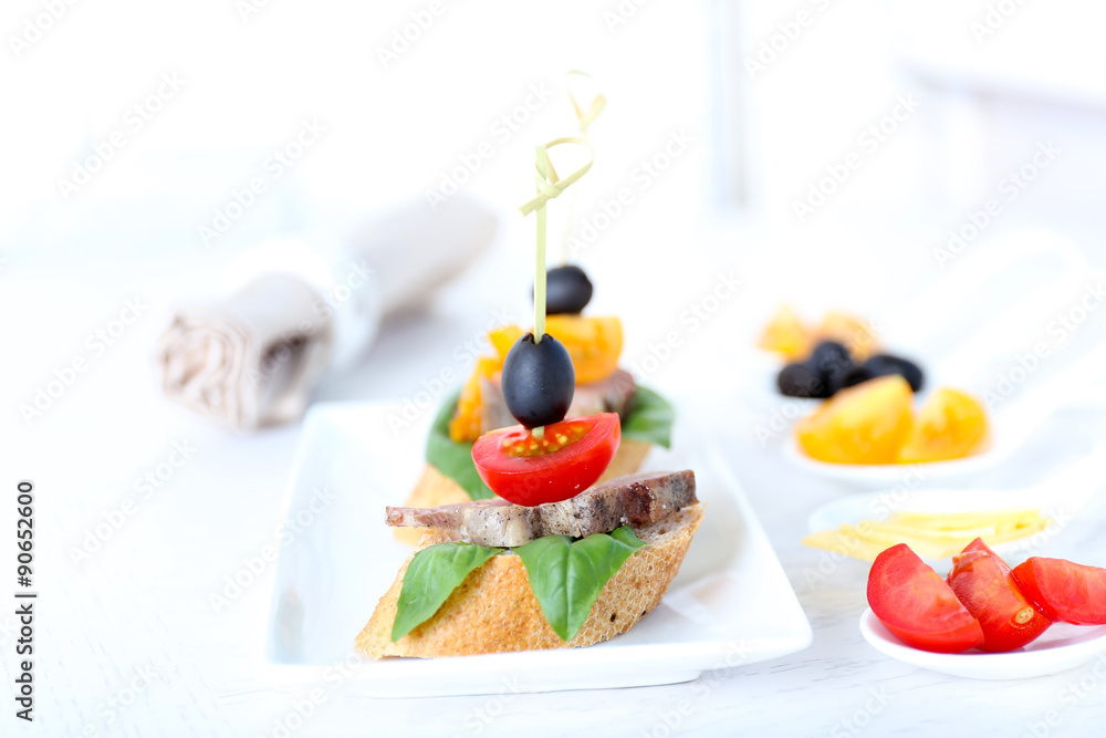 Tasty canapes on wooden table, close up