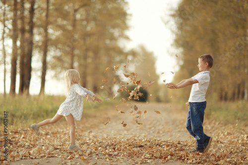 boy playing with a girl in the autumn on the outside