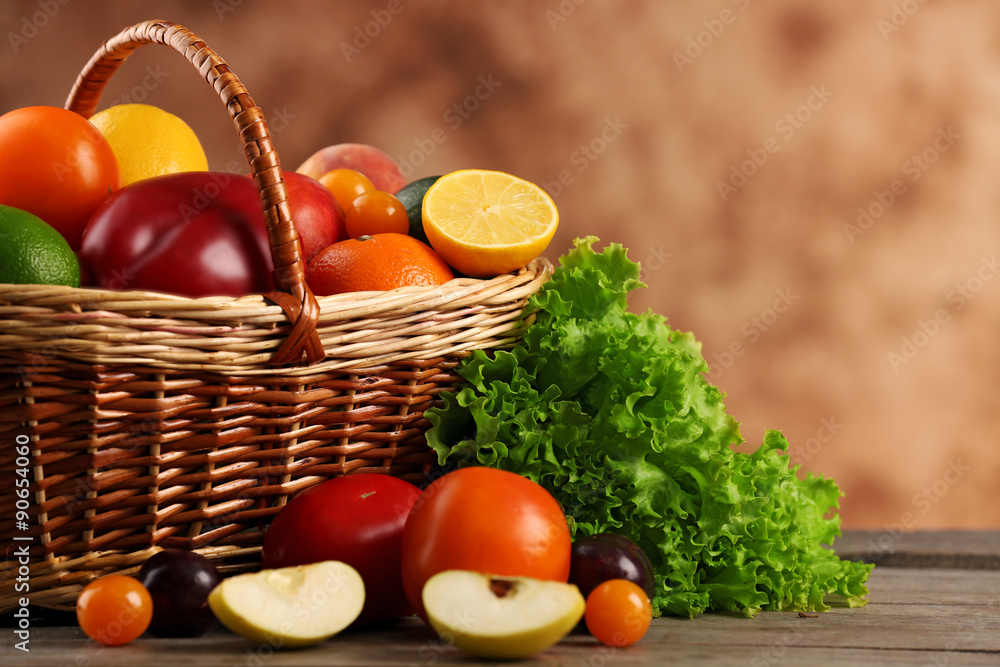 Heap of fresh fruits and vegetables in basket on wooden table close up Heap of fresh fruits and vegetables in basket on wooden table close up