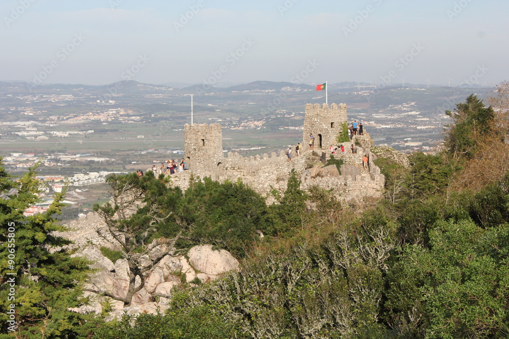 Overview of Castle of the Moors and Sintra cityscape and valley from the top of the hill, with people on the Castle's tower in the background