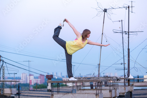 relaxing yoga on the roof on background antenna at sunset