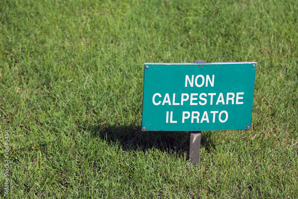 lawn with grass and sign written with words in Italian
