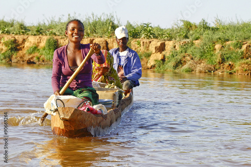Malagasy people crossing the inlets in an outrigger canoe