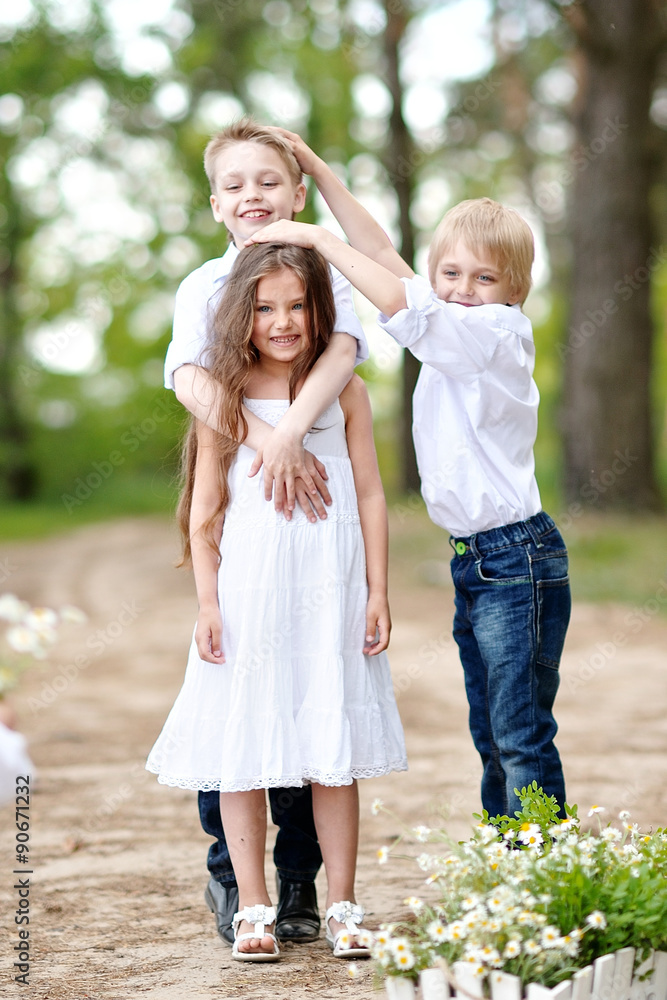 three children playing on meadow in summer three children playing on meadow in summer