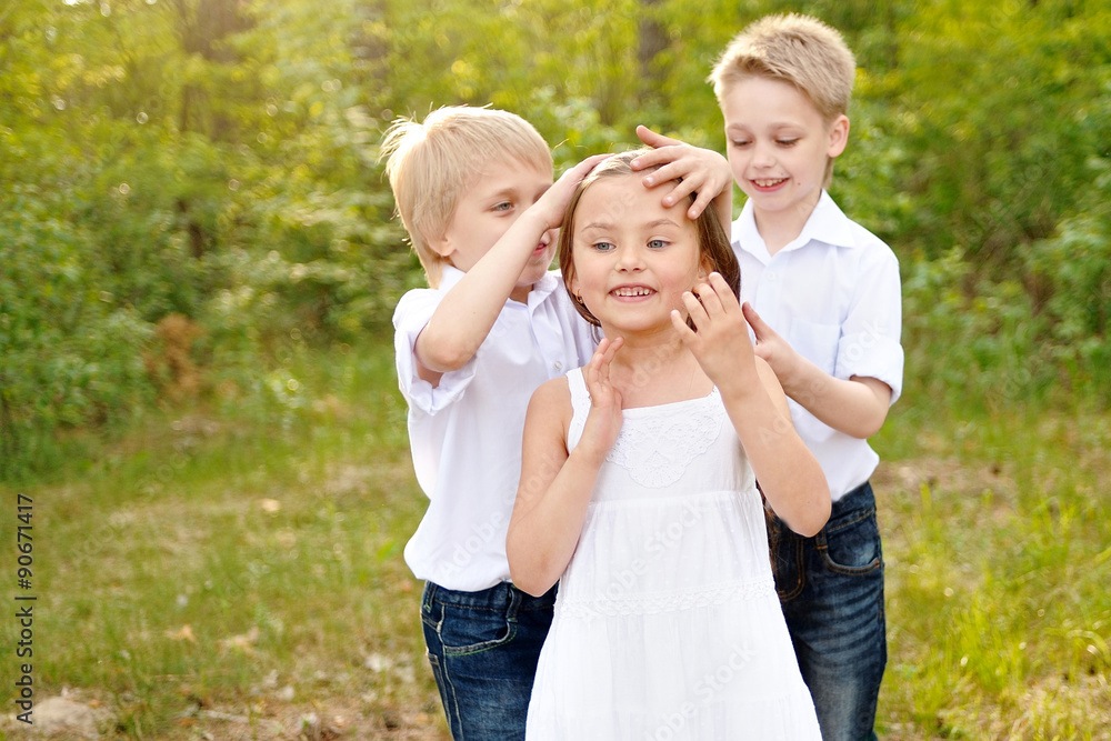 three children playing on meadow in summer three children playing on meadow in summer