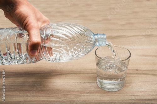 acqua nella bottiglia versata in un bicchiere trasparente