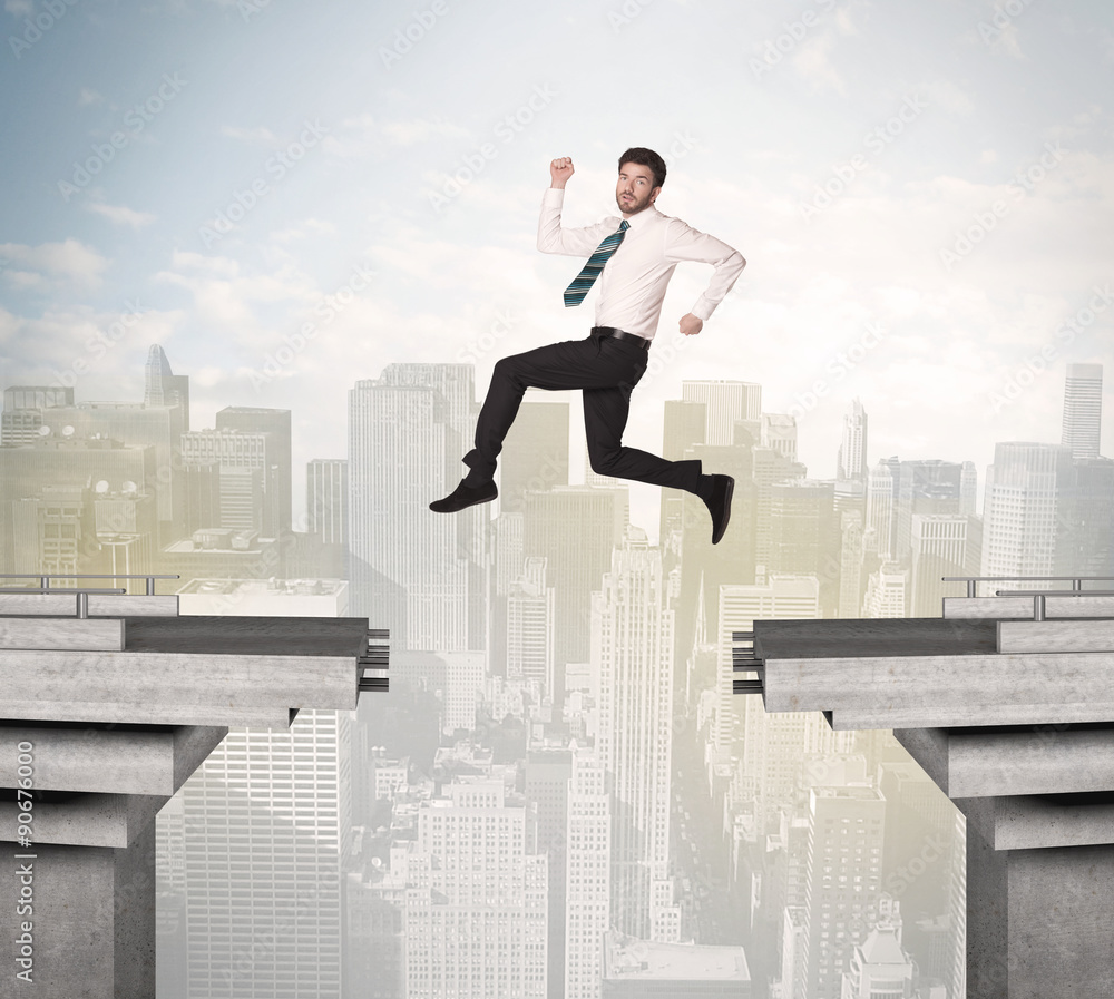 Energetic business man jumping over a bridge with gap Energetic business man jumping over a bridge with gap