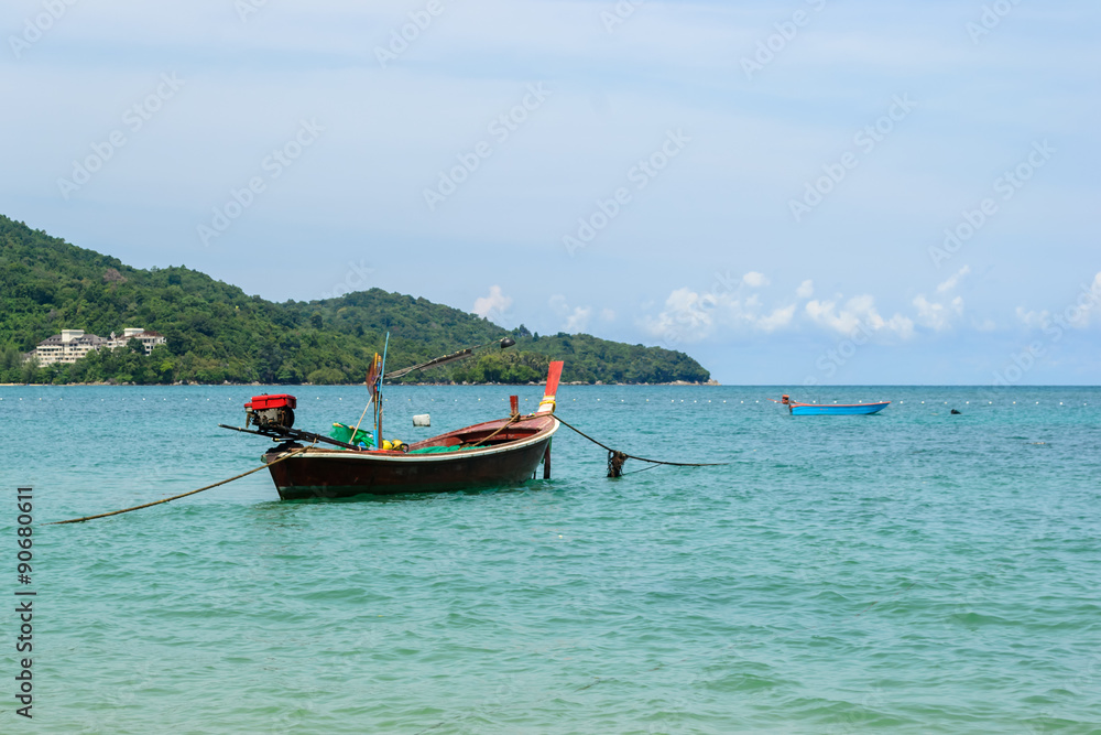 Long tail Boats moored at Nai Yang Beach, Phuket Thailand with blue sky background