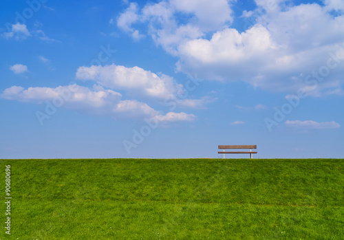 Bank auf einem Damm mit schönen Wolken breit
