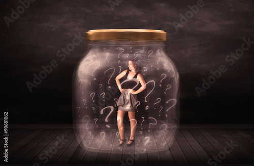 Businesswoman locked into a jar with question marks concept photo