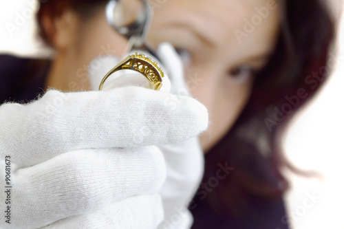 ルーペを除いて指輪を鑑定する女性