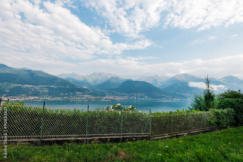 Fototapeta premium Laghetto di Piona in Italy, Alps, Europe. Como lake landscape, clouds, mountains and gardens.