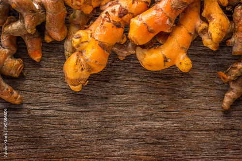 Stack of turmeric on grunge wooden background.