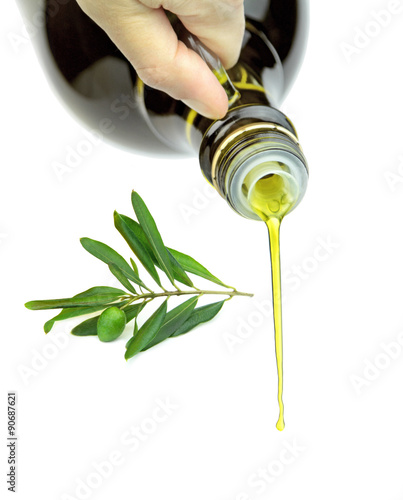 Pouring extra virgin olive oil from glass bottle.