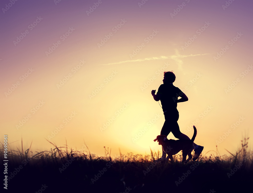 Runner with dog silhouettes at the sunset