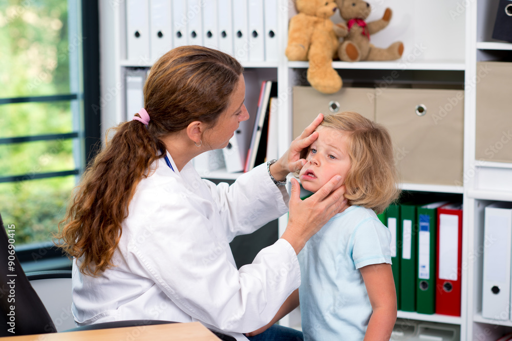Fototapeta premium female pediatrician in white lab coat examined little patient