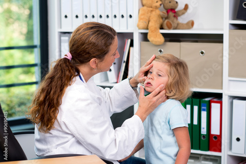 female pediatrician in white lab coat examined little patient