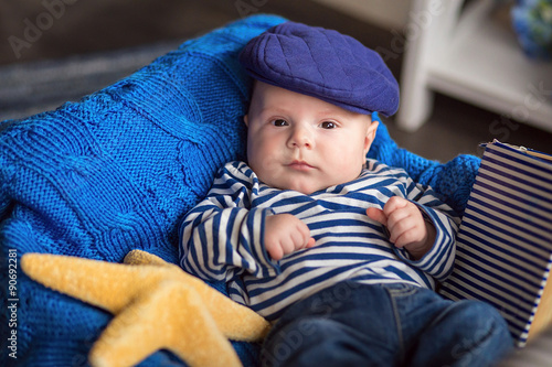 Portrait of a cute little boy in a cap and vest