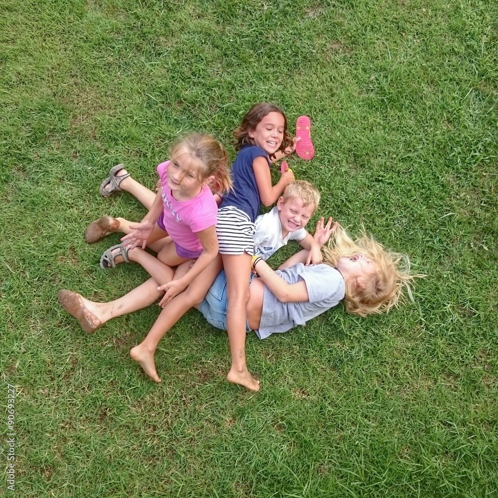 Niños jugando en el césped foto de Stock | Adobe Stock