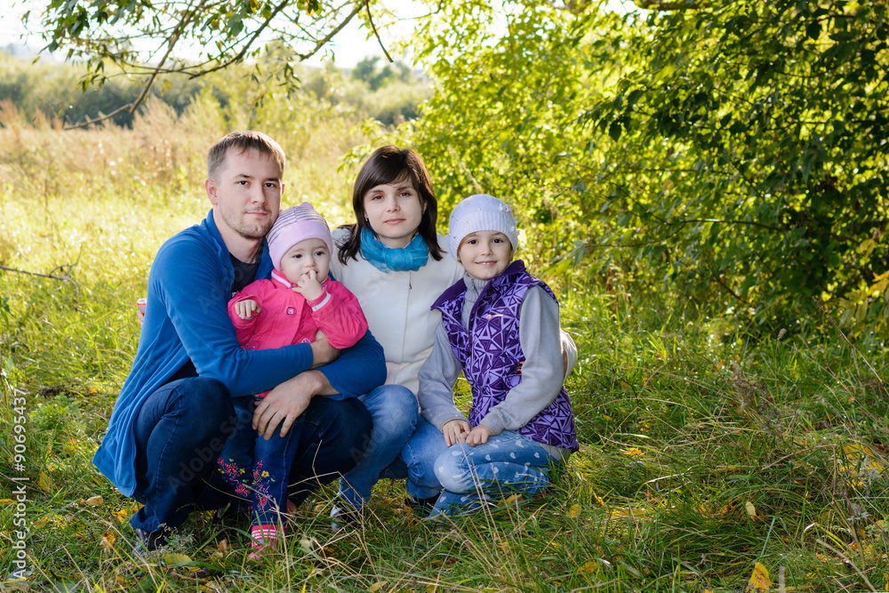 Family resting the meadow in autumn