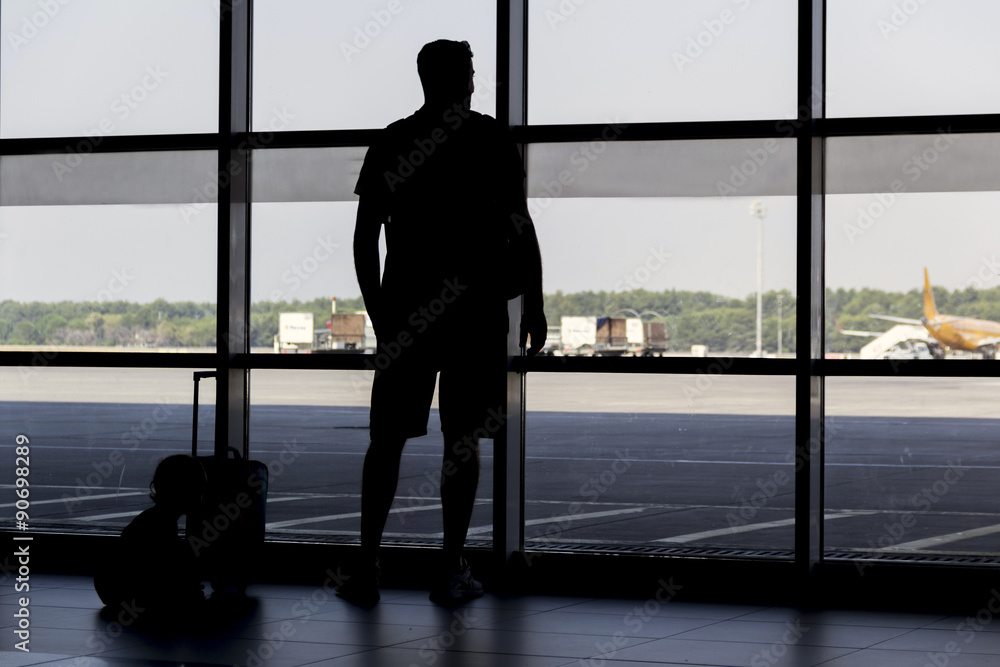 silhouette man at airport in front of window