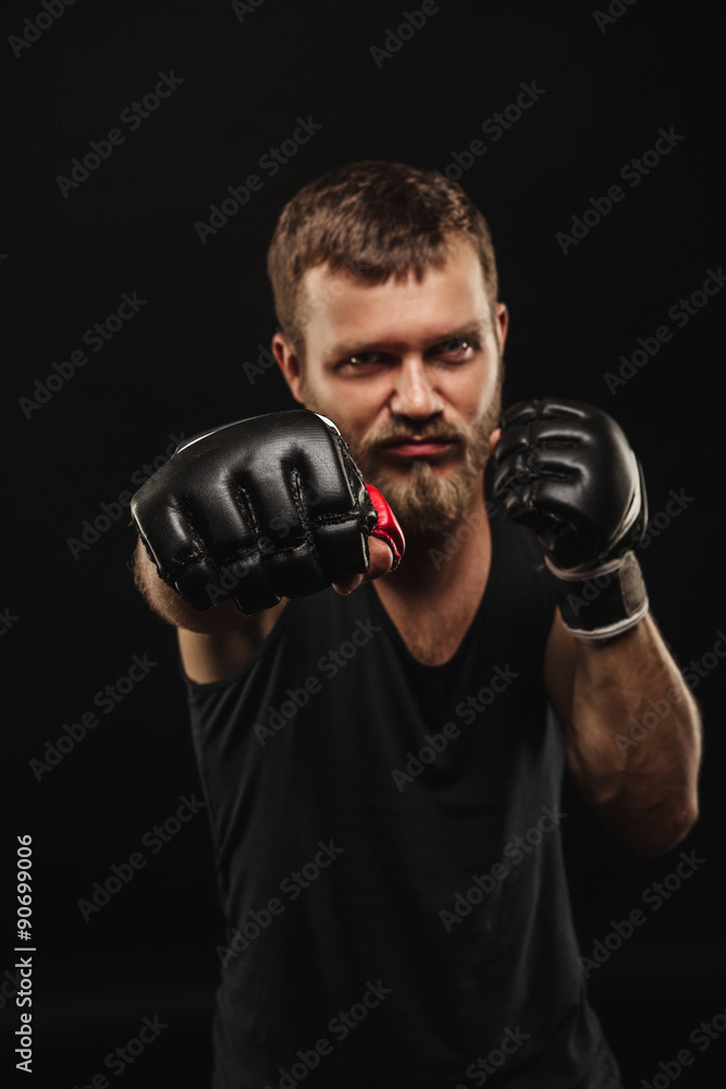 Athletic bearded boxer with gloves on a dark background Athletic bearded boxer with gloves on a dark background