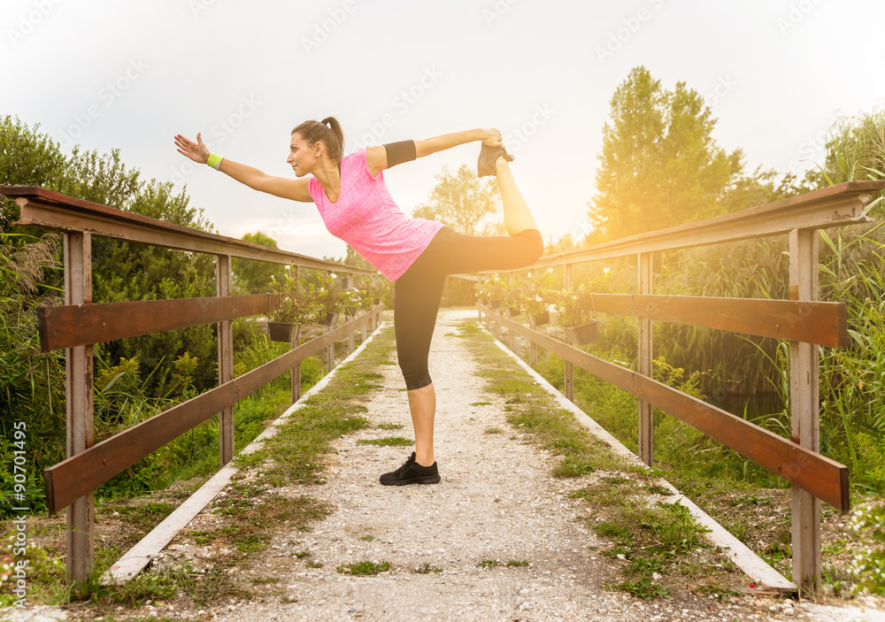 Attractive young runner woman doing stretching exercises.