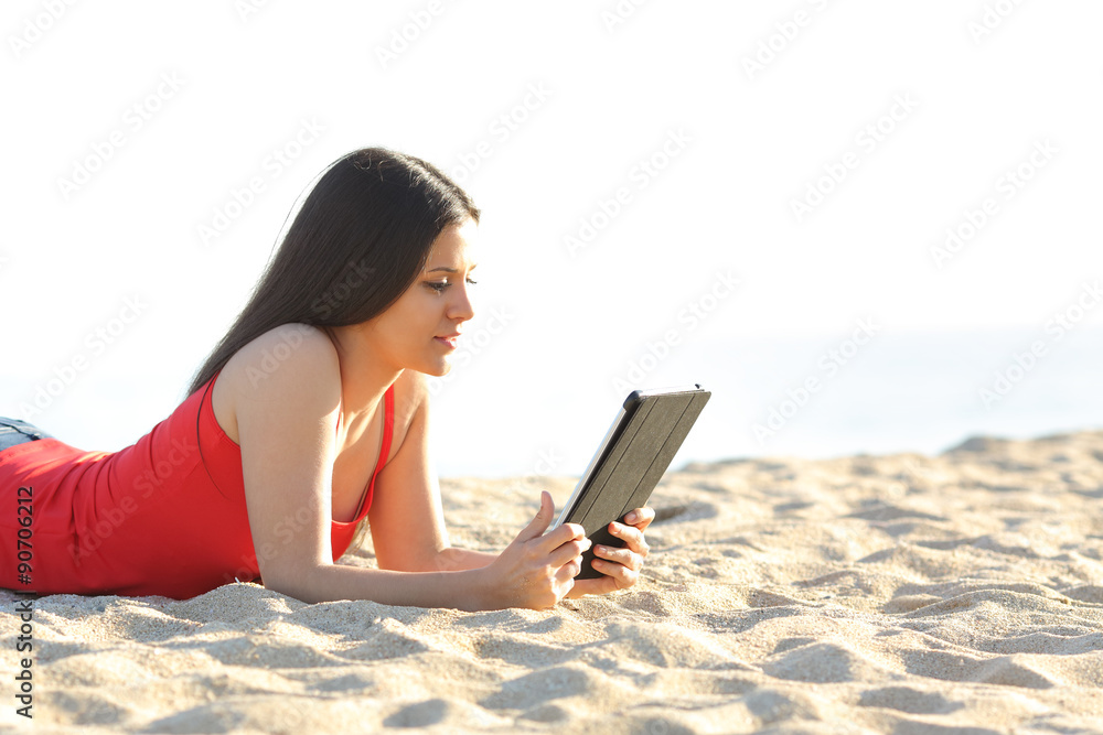 Girl reading an ebook or tablet on the beach Girl reading an ebook or tablet on the beach