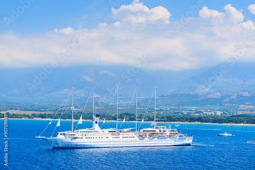 View of cruise ship mooring on blue sea in Calvi bay, Corsica island, France