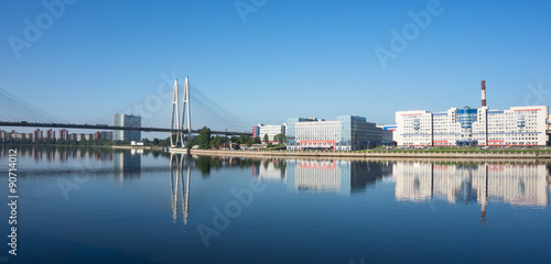 early morning reflections on the Neva River of new construction, buildings, cable bridge, and St. Petersburg skyline