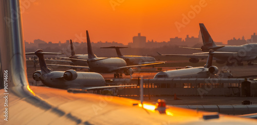 Sunset at the airport with airplanes ready to take off photo
