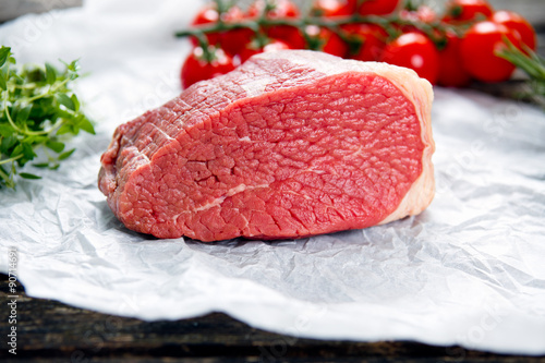 Konstfotografi a pieces of fresh meat, beef slab, decorated with greens and vegetables